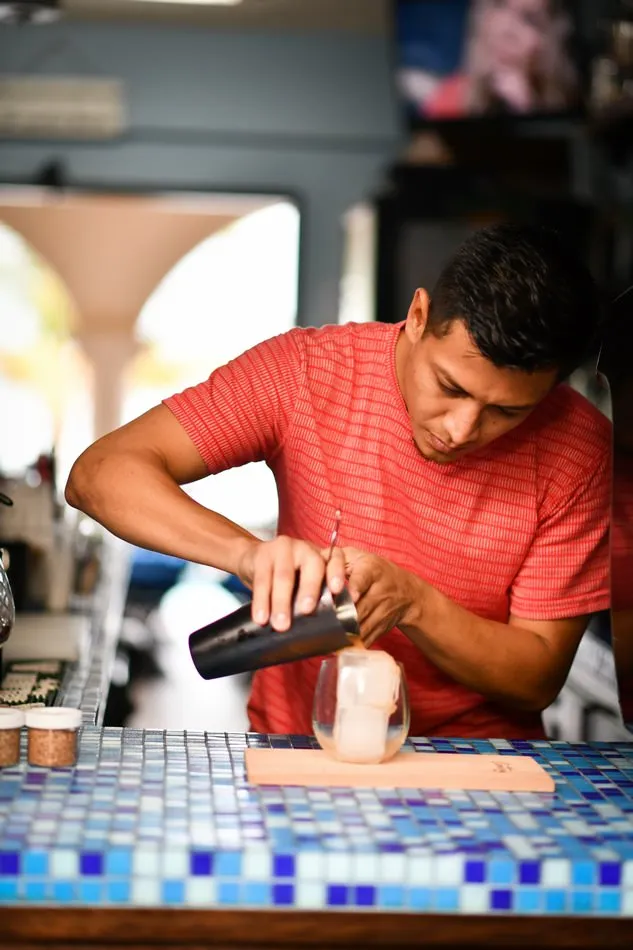 A bartender crafting a cocktail at the pool bar