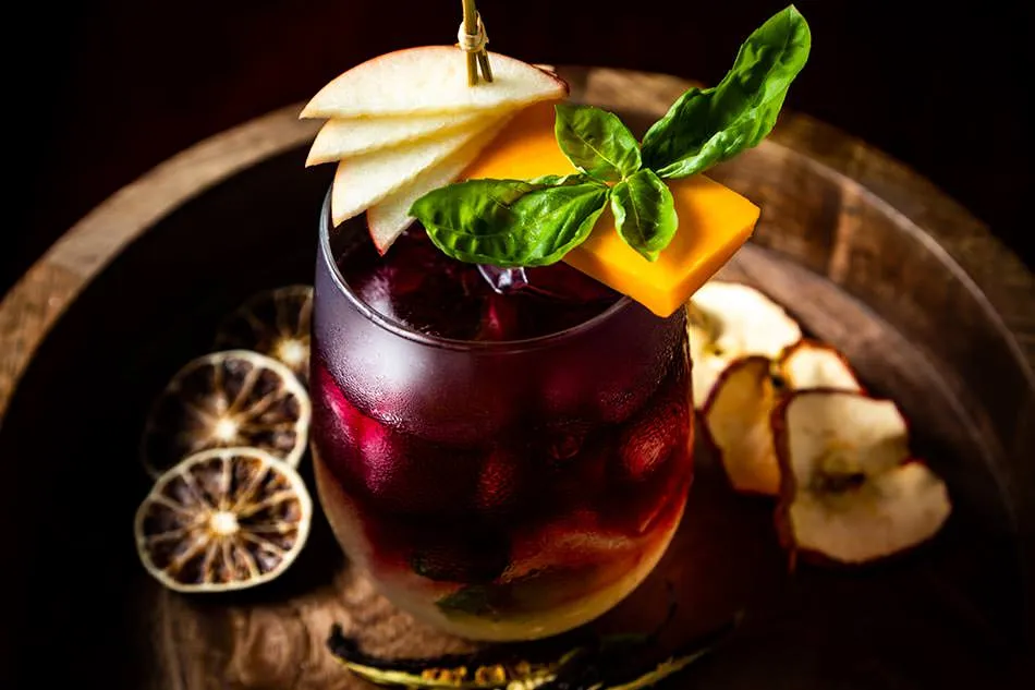 A craft cocktail garnished with tropical fruit