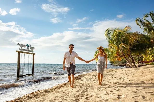 A couple on a beach swing over the water