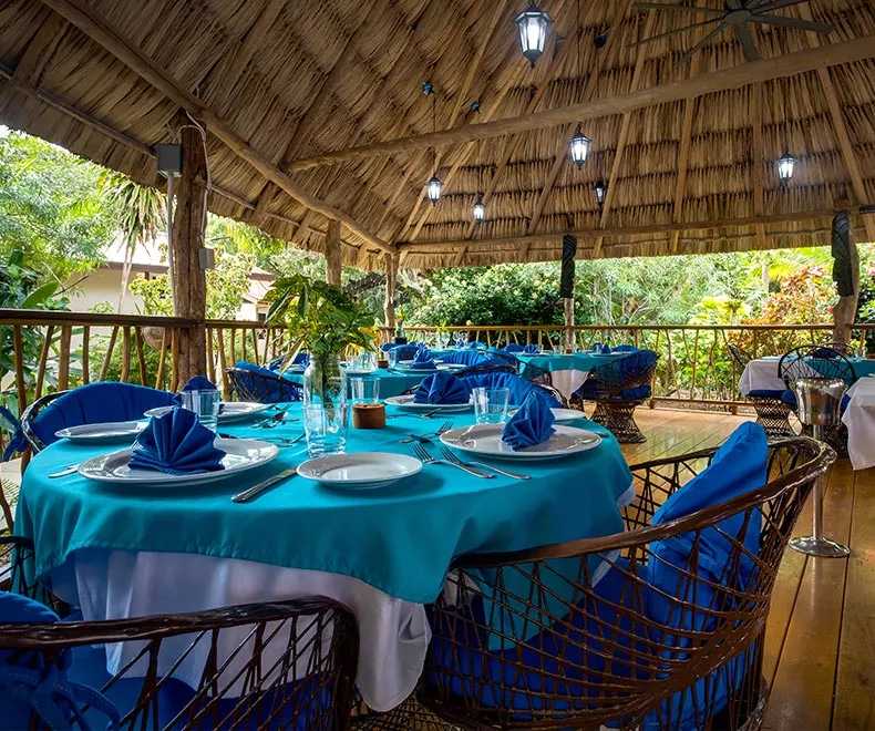 The Breezeway restaurant — open-air dining under a thatched palapa by the sea