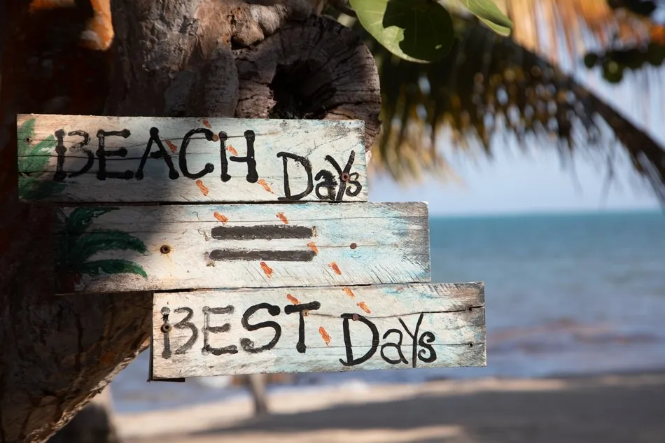 A hand-painted 'Beach Days = Best Days' sign in Placencia